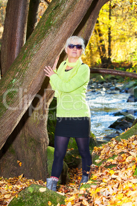 Woman alone in autumn atmosphere at the river