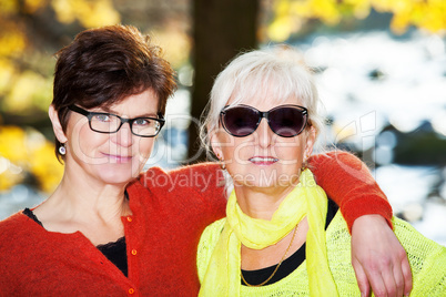 Two middle-aged women hugging in nature