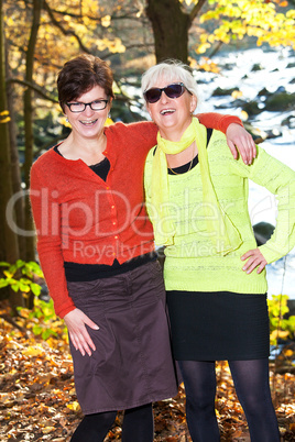 Two middle-aged women hugging in nature