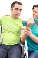 Physical therapist works with patient in lifting hands weights.