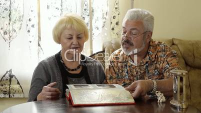 Retired couple looking at an album indoor