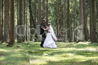 Bride and groom dancing in the forest