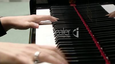 The fingers of the musician on the piano keys
