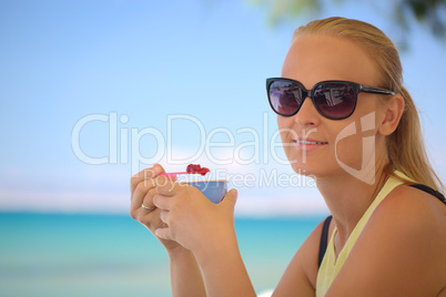 Young woman eating ice-cream on the beach