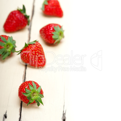 fresh organic strawberry over white wood