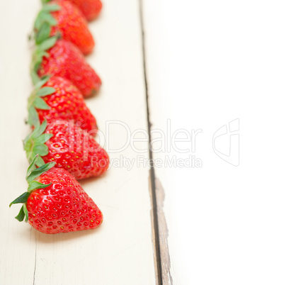 fresh organic strawberry over white wood