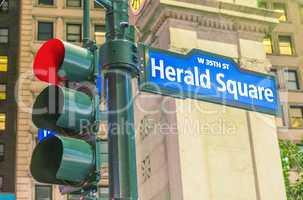 Herald Square street sign and traffic light in Manhattan at nigh