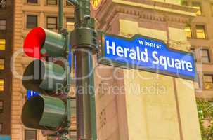 Herald Square street sign and traffic light in Manhattan at nigh