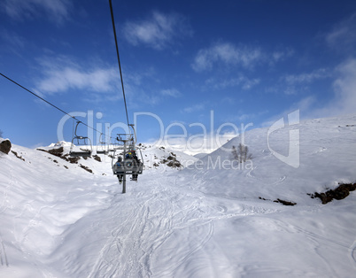 Chair-lift and off-piste slope in sun day