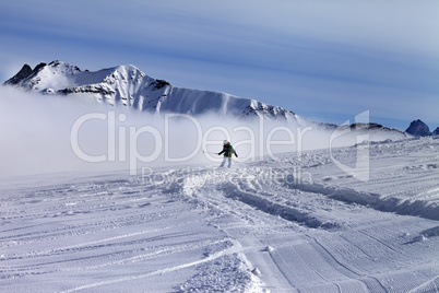 Snowboarder downhill on off-piste slope with newly-fallen snow
