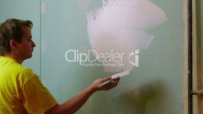 Construction Worker Applying Plaster on a Drywall, closeup