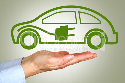 Hand holding symbolic electric car