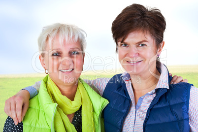 Two middle-aged friends hugging and looking forward