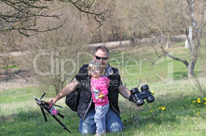 Father and her daughter playing in the nature with a toy car