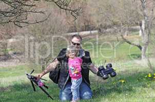 Father and her daughter playing in the nature with a toy car