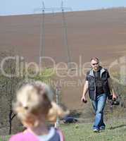 Father and her daughter playing in the nature with a toy car