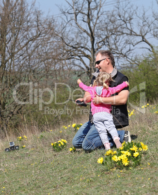 Father and her daughter playing in the nature with a toy car