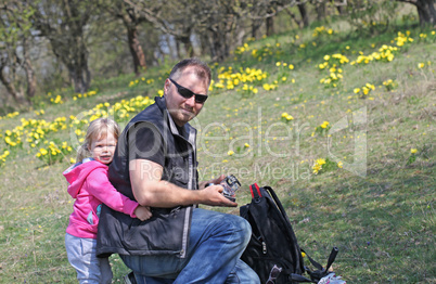 Father and her daughter playing in the nature with a toy car Father and her daughter playing in the nature with a toy car