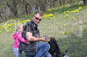 Father and her daughter playing in the nature with a toy car