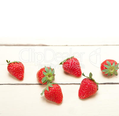 fresh organic strawberry over white wood