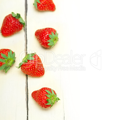 fresh organic strawberry over white wood