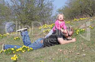 A man with a young blonde daughter playing in the  nature