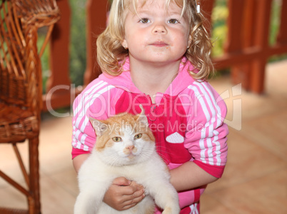 Cute little girl holding a red cat