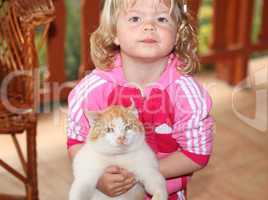 Cute little girl holding a red cat