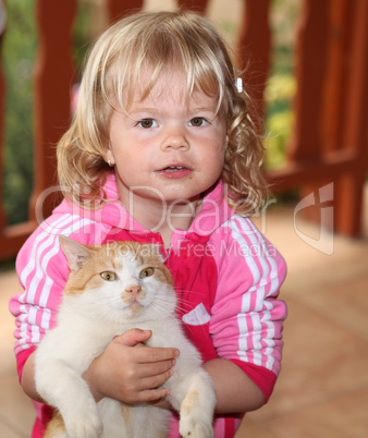 Cute little girl holding a red cat