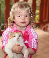 Cute little girl holding a red cat