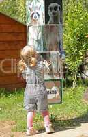 Cute girl playing at the zoo with animals board