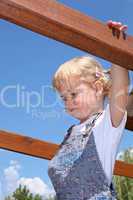 Little girl having fun at the top of a jungle gym