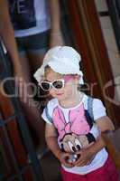 Young fashionable girl dressed up in a hat and  sunglasses