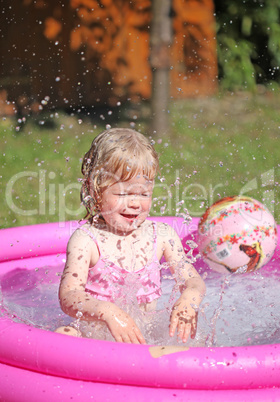 Portrait of little girl enjoying her vacation in the pool outdoors