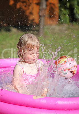 Portrait of little girl enjoying her vacation in the pool outdoors