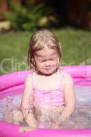 Portrait of little girl enjoying her vacation in the pool outdoors