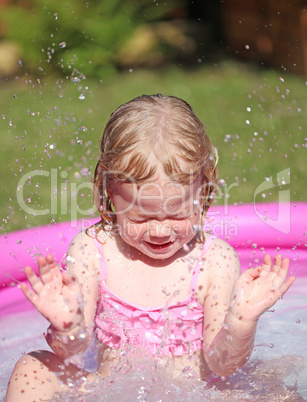 Portrait of little girl enjoying her vacation in the pool outdoors