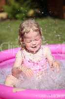 Portrait of little girl enjoying her vacation in the pool outdoors