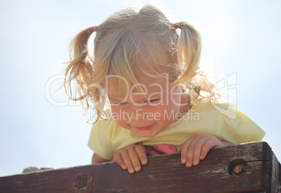 Little girl having fun at the top of a jungle gym