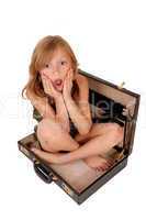 Girl sitting in briefcase.
