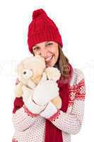 Cute brunette in warm clothing hugging teddy bear