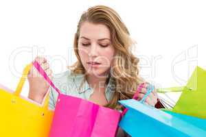 Blonde woman opening gift bag and looking on it
