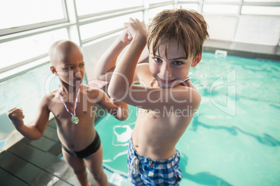 Little boys standing by the pool with medals