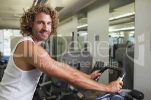 Side view portrait of man working out on exercise bike
