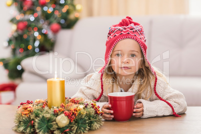 Cute little girl holding mug at Christmas