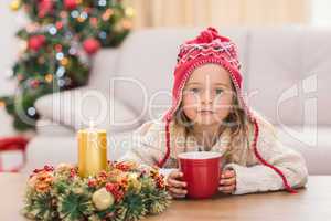 Cute little girl holding mug at Christmas