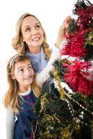 Festive mother and daughter decorating christmas tree