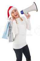 Festive blonde holding gift bags and megaphone