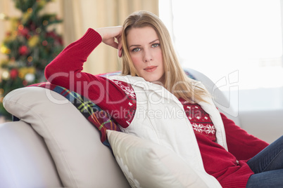 Cute blonde sitting on couch posing