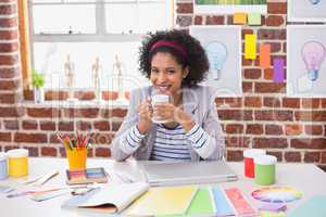 Portrait of female interior designer with coffee cup at desk
